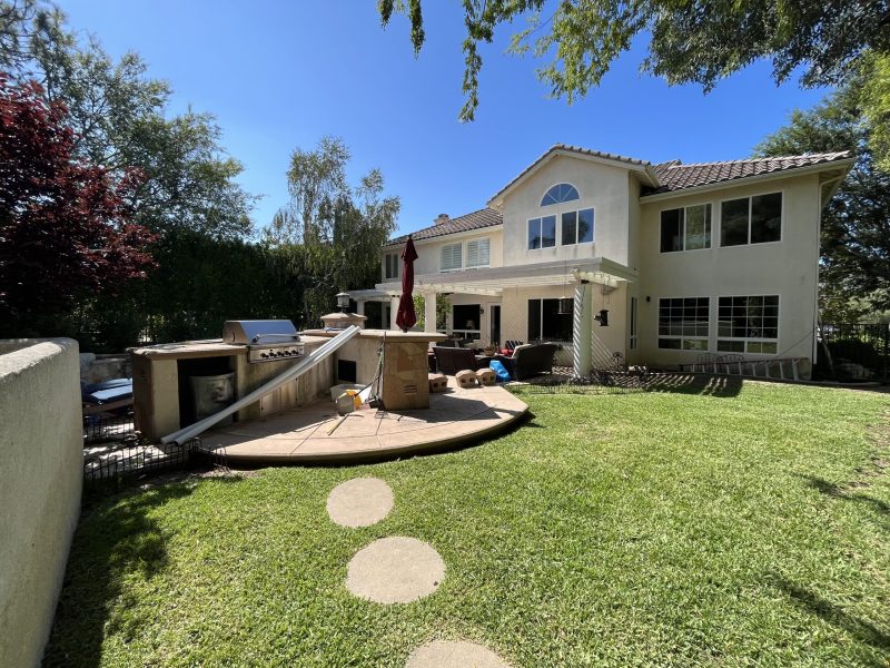 Existing backyard mid-construction with hardscape and built-in grill island before design began