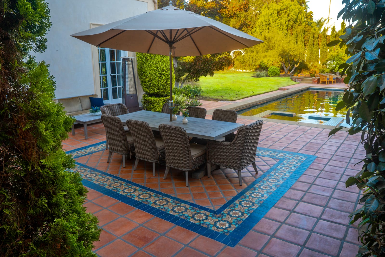 Spanish Estate dining patio with decorative tile beside the pool
