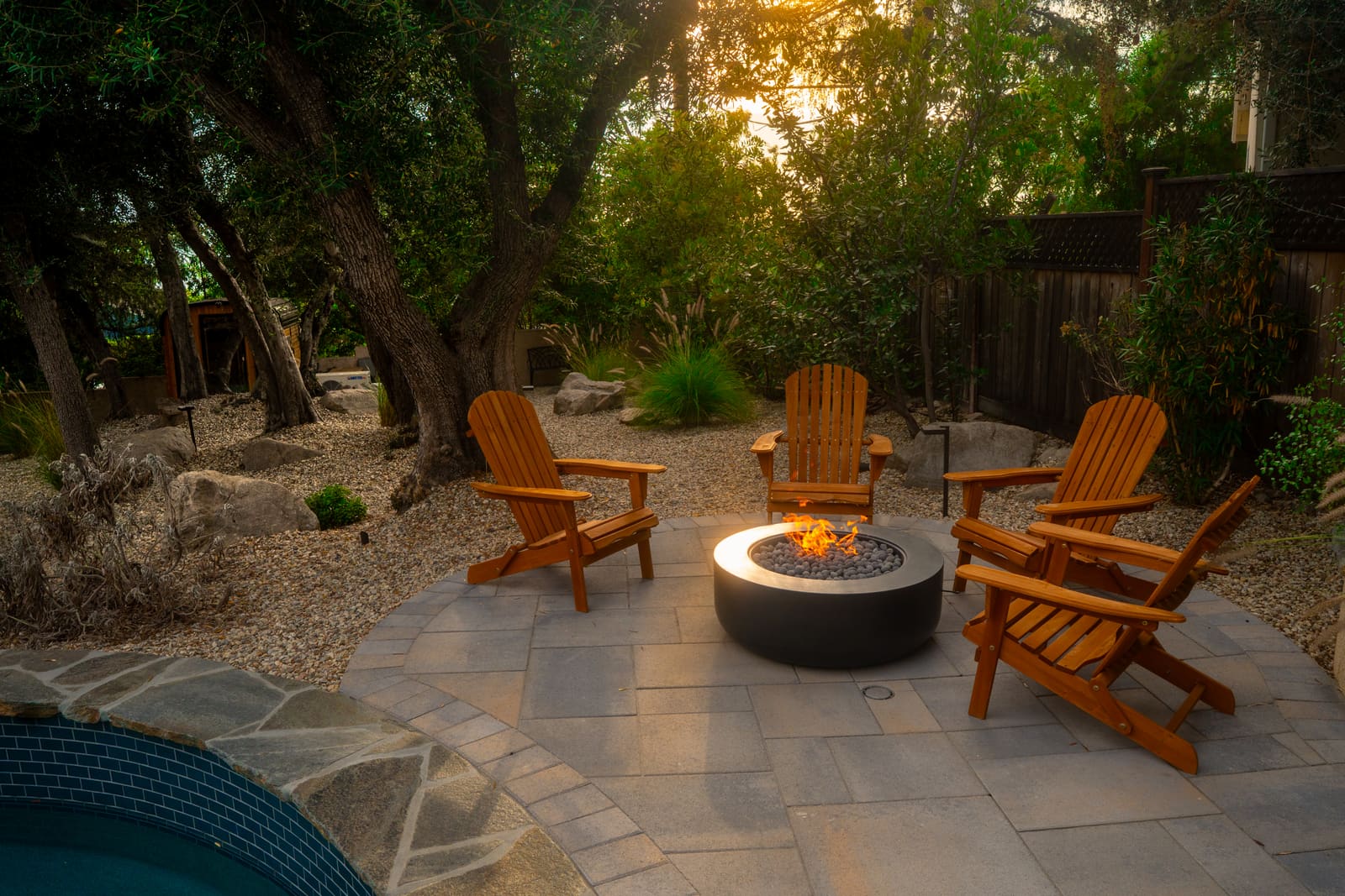 The fire bowl patio under mature trees at sunset