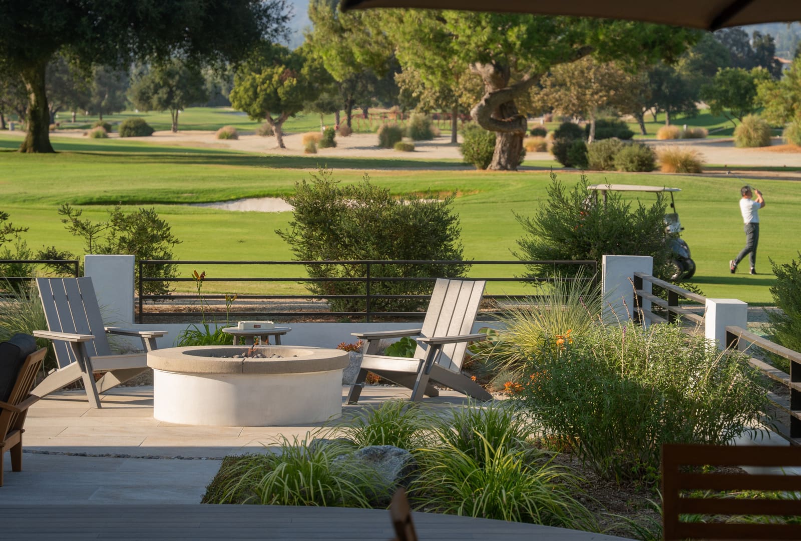 The cable-rail fence along the property edge, with grasses and the fairway behind