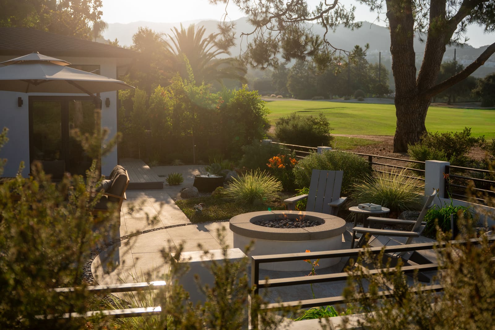 The fire pit terrace at sunset, with mountains beyond the golf course