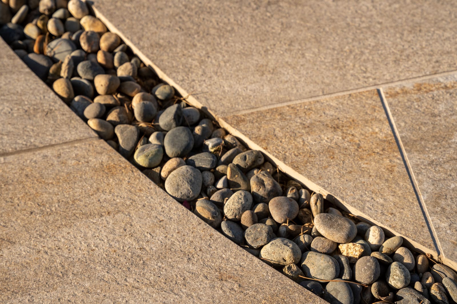Detail of a river cobble band set into the concrete paving