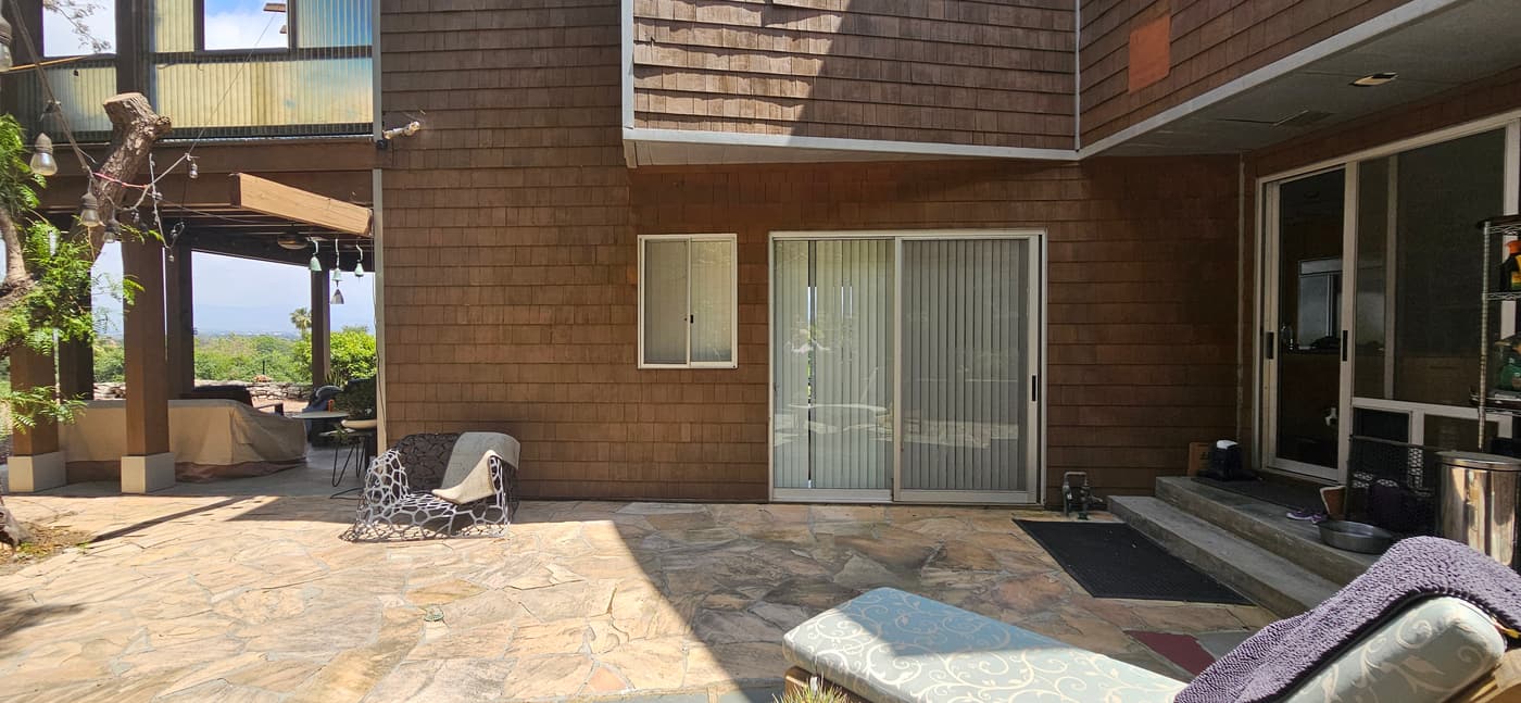 The rear of the house before construction, with sliding doors onto the existing flagstone patio