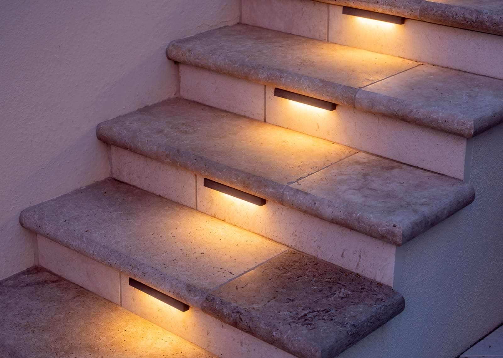 Stone steps at night, each tread washed by a recessed step light