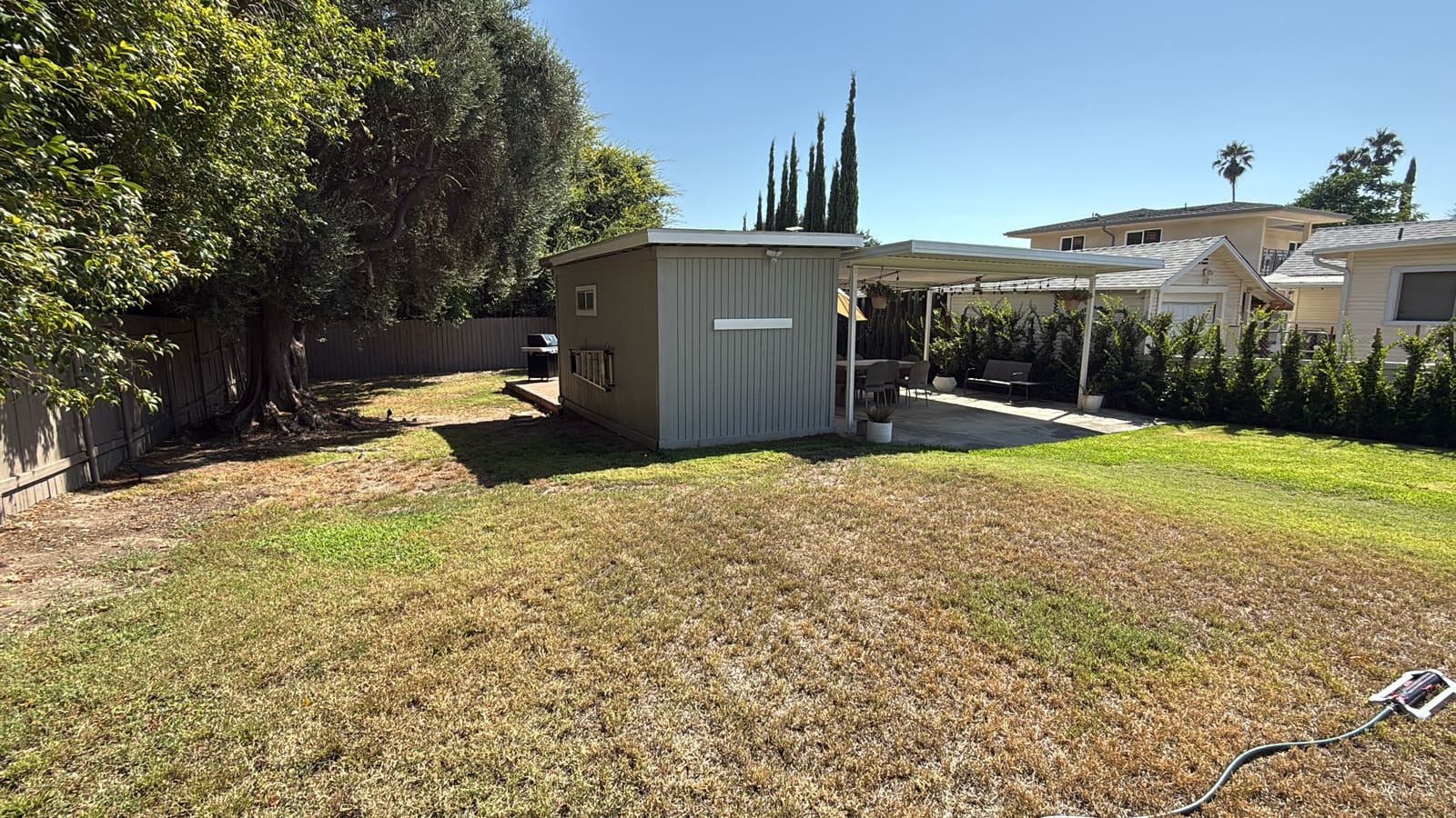 The rear of the yard before construction, with the utility shed and carport structure