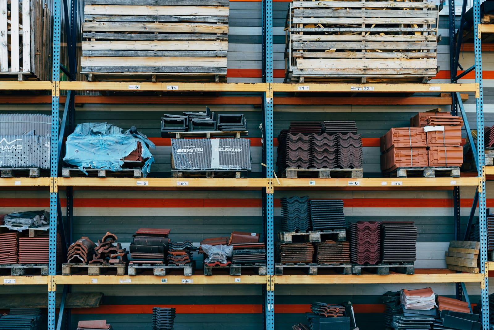Pallets of tile and building materials stacked on racking at a supply yard