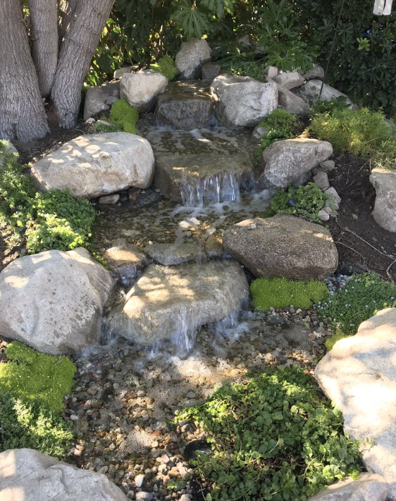 A close-up of the tiered rock waterfall built for this backyard Zen space