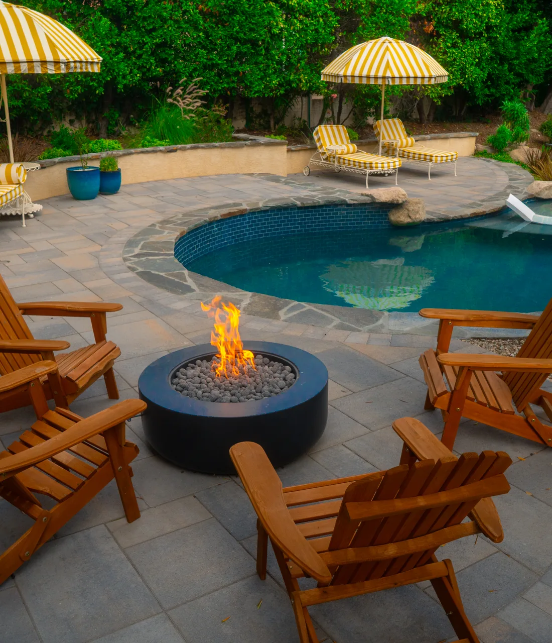 Fire pit lounge and freeform pool in a Pacific Outdoor Living backyard