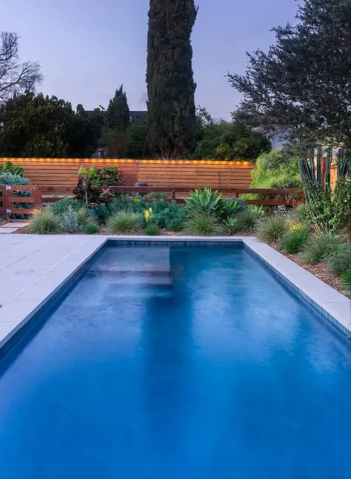Indoor pool in LA with walkway and garden surrounding in the evening