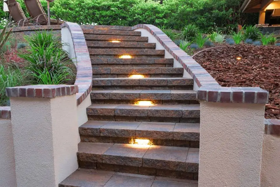 Paving stone pathway with step lighting and prick accents.
