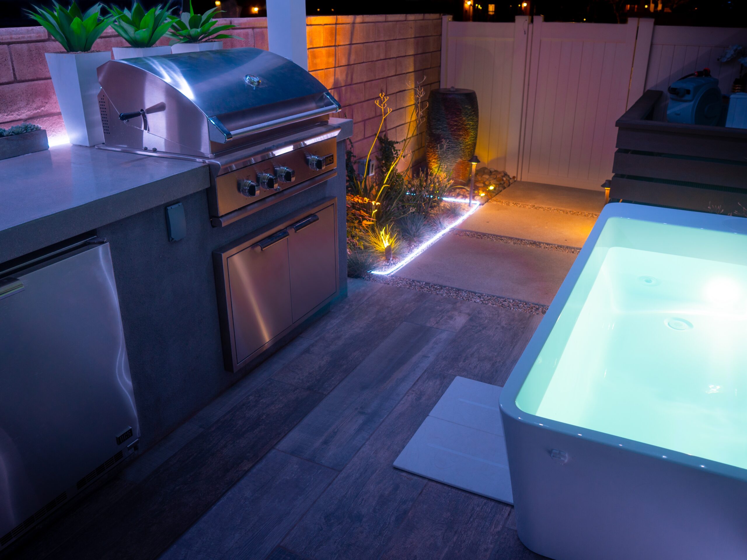 Completed side yard transformation of small space with kitchen, dining and seating area, and firepit built by Pacific Outdoor Living