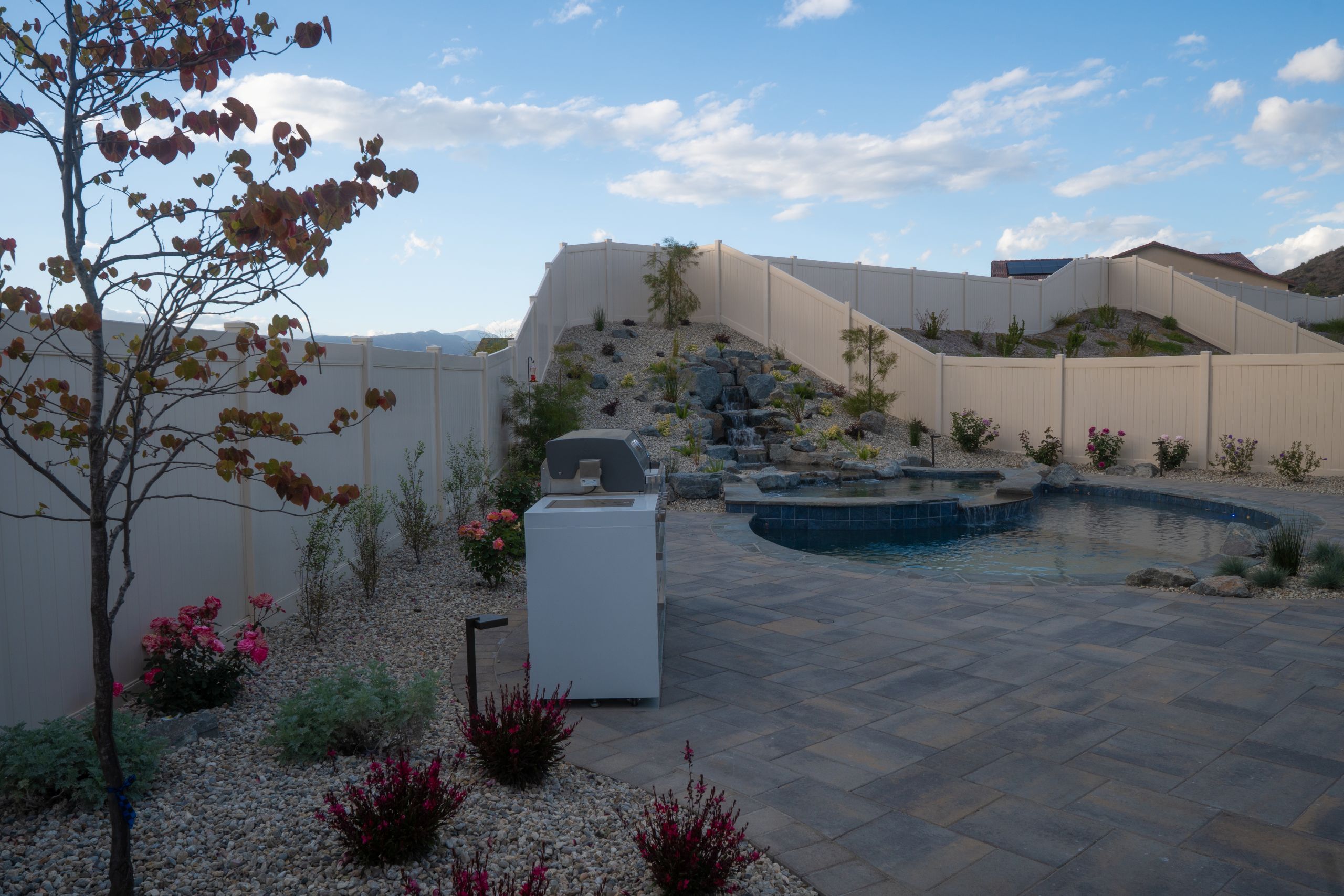 Completed backyard with waterfall, pool and outdoor kitchen in Southern California designed and built by Pacific Outdoor Living