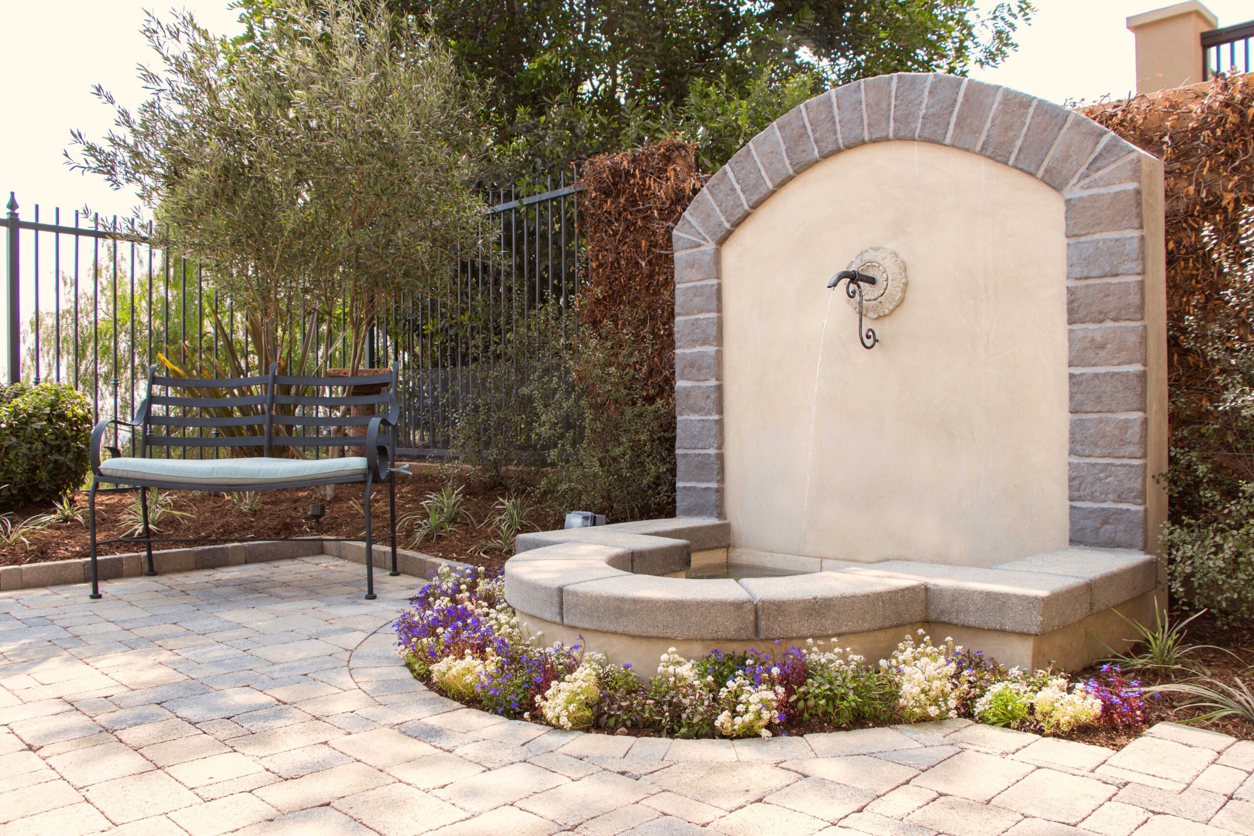 Wall fountain water feature in a Mediterranean landscape design