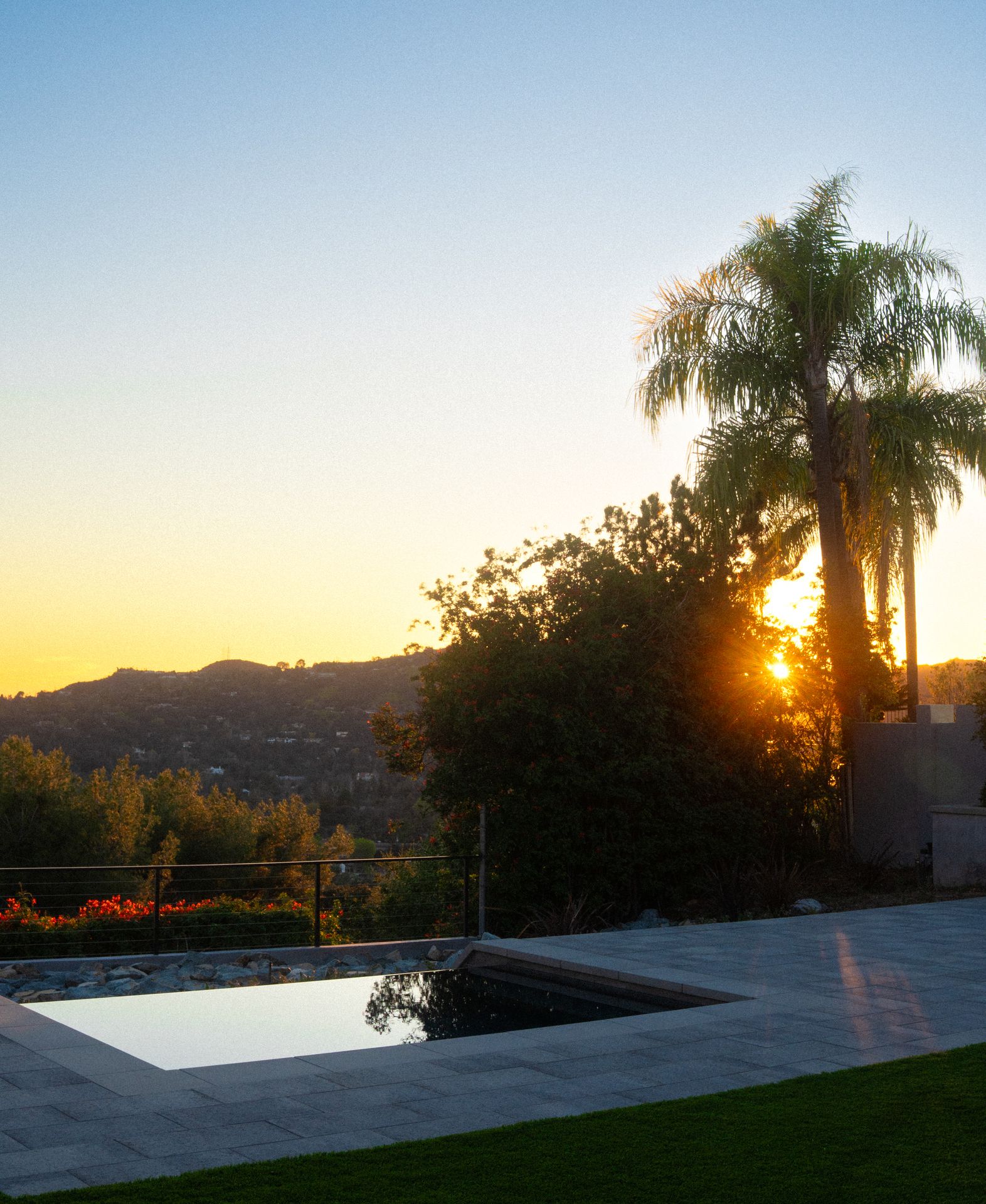 Freeform pool with a natural rock waterfall built into a hillside slope