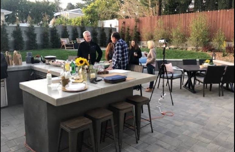 Backyard entertaining space with outdoor kitchen island, firepit, and comfortable seating for 20+ people