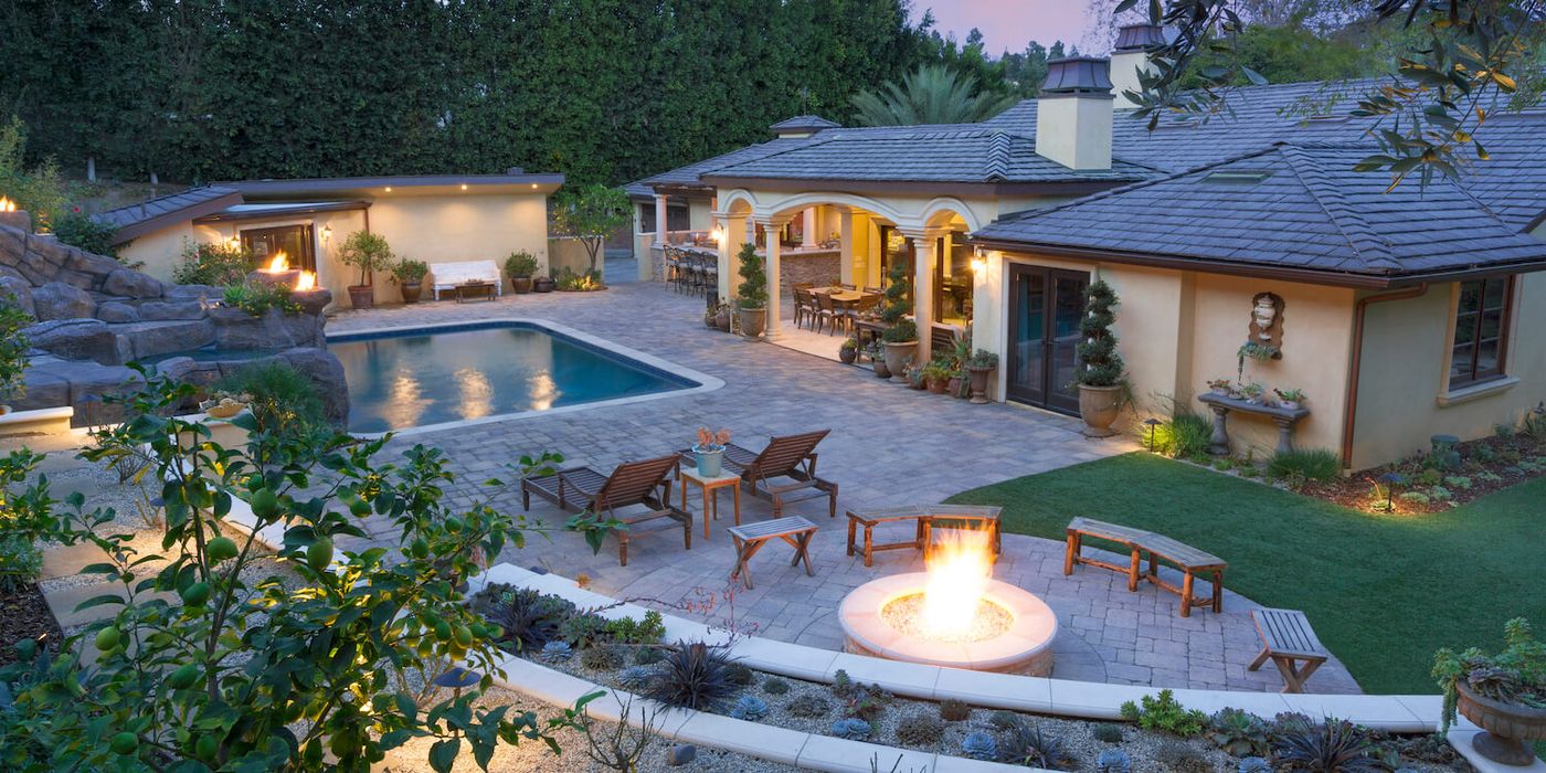 Garden seating area beside a stone stepping-stone path shaded by mature trees