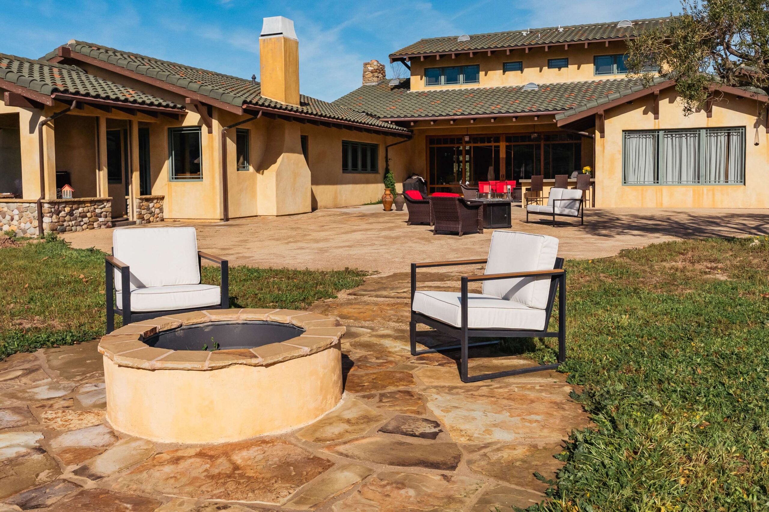 Completed backyard transformation with outdoor kitchen and firepit area by Pacific Outdoor Living