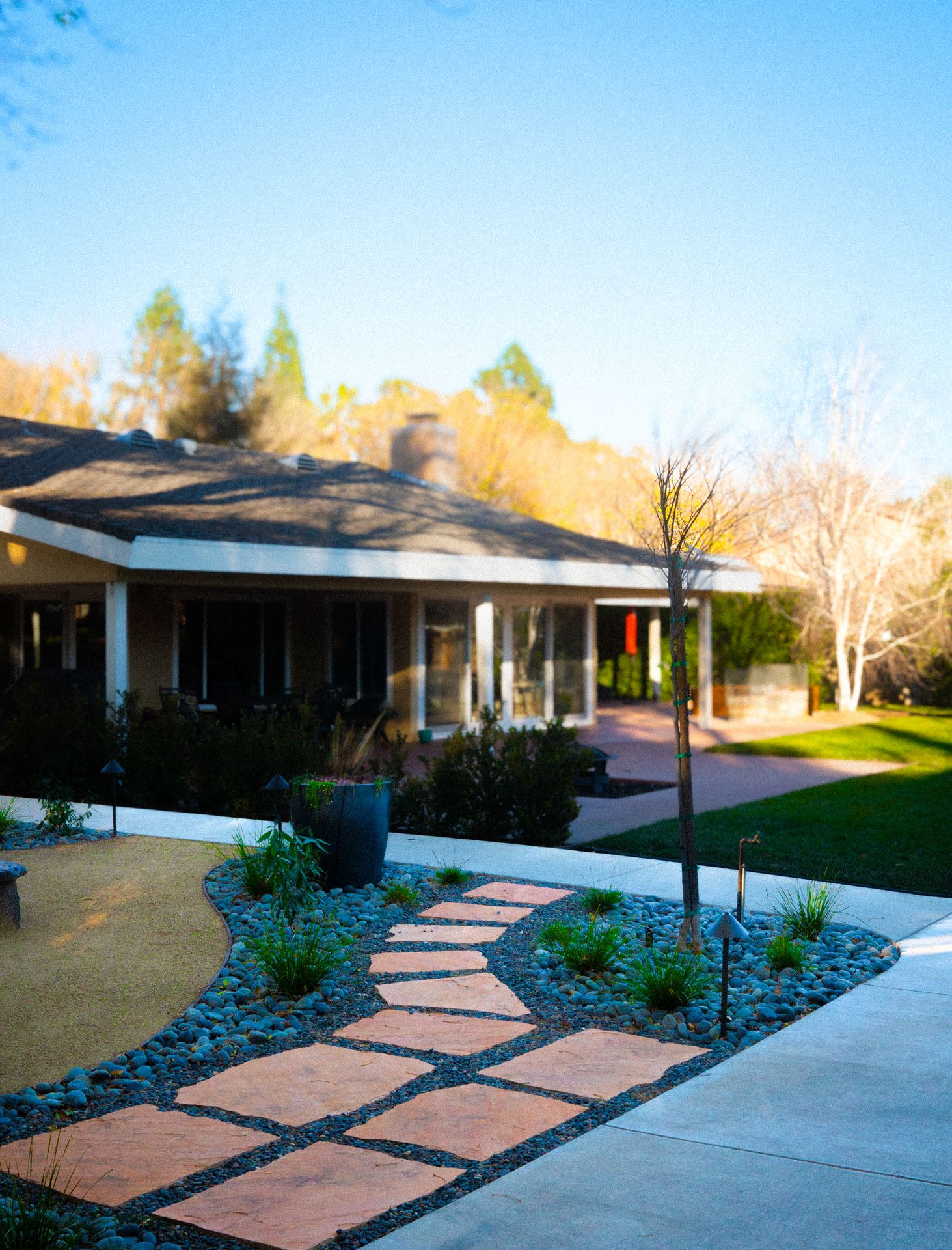 Modern paver driveway with landscape design and stone accents