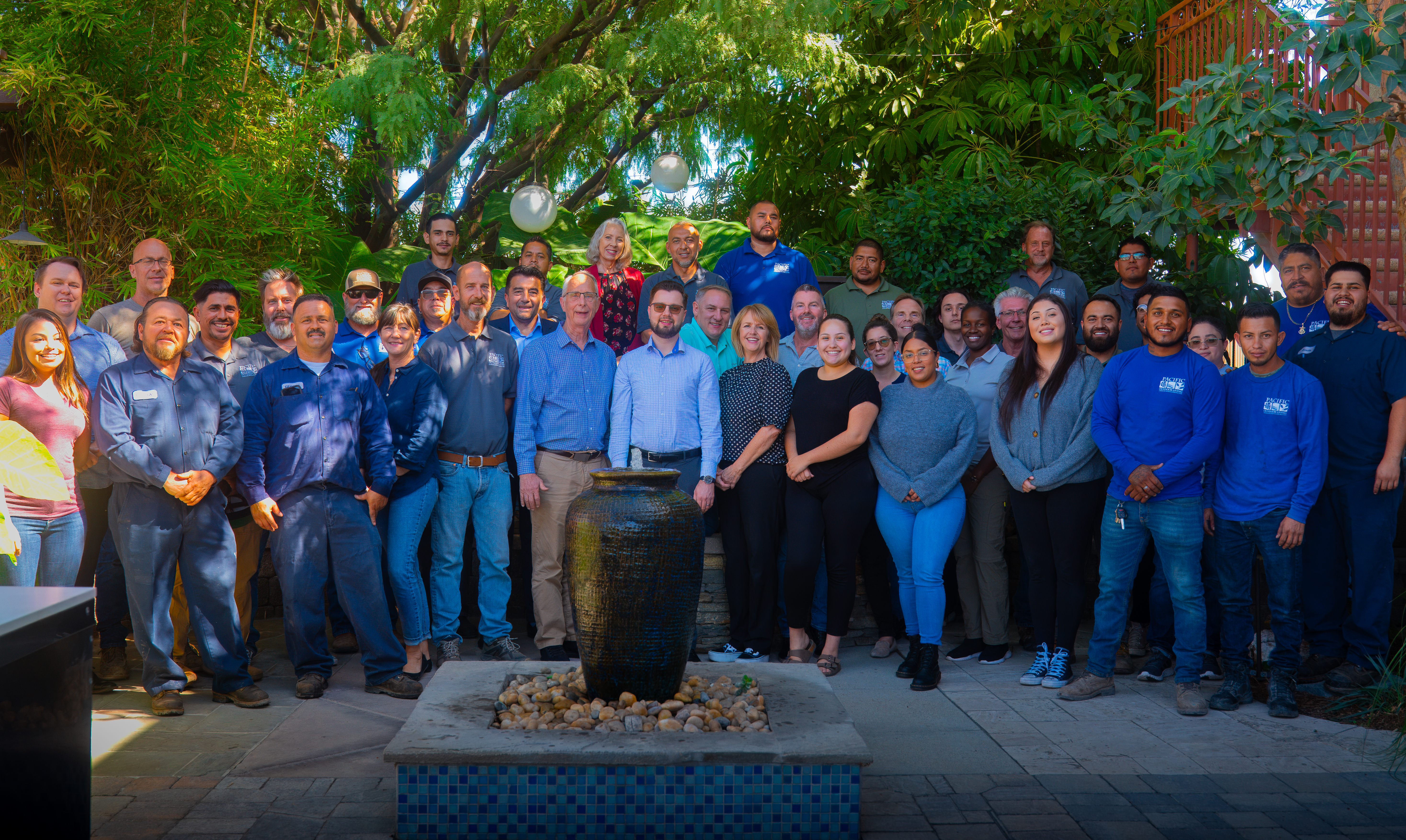 Pacific Outdoor Living in-house team standing together in the company showroom courtyard