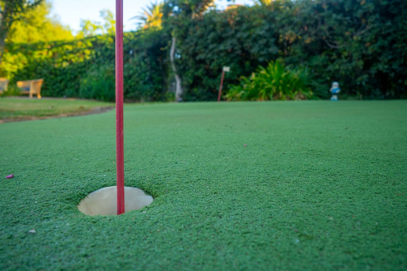 Custom backyard putting green with artificial turf designed for residential outdoor living