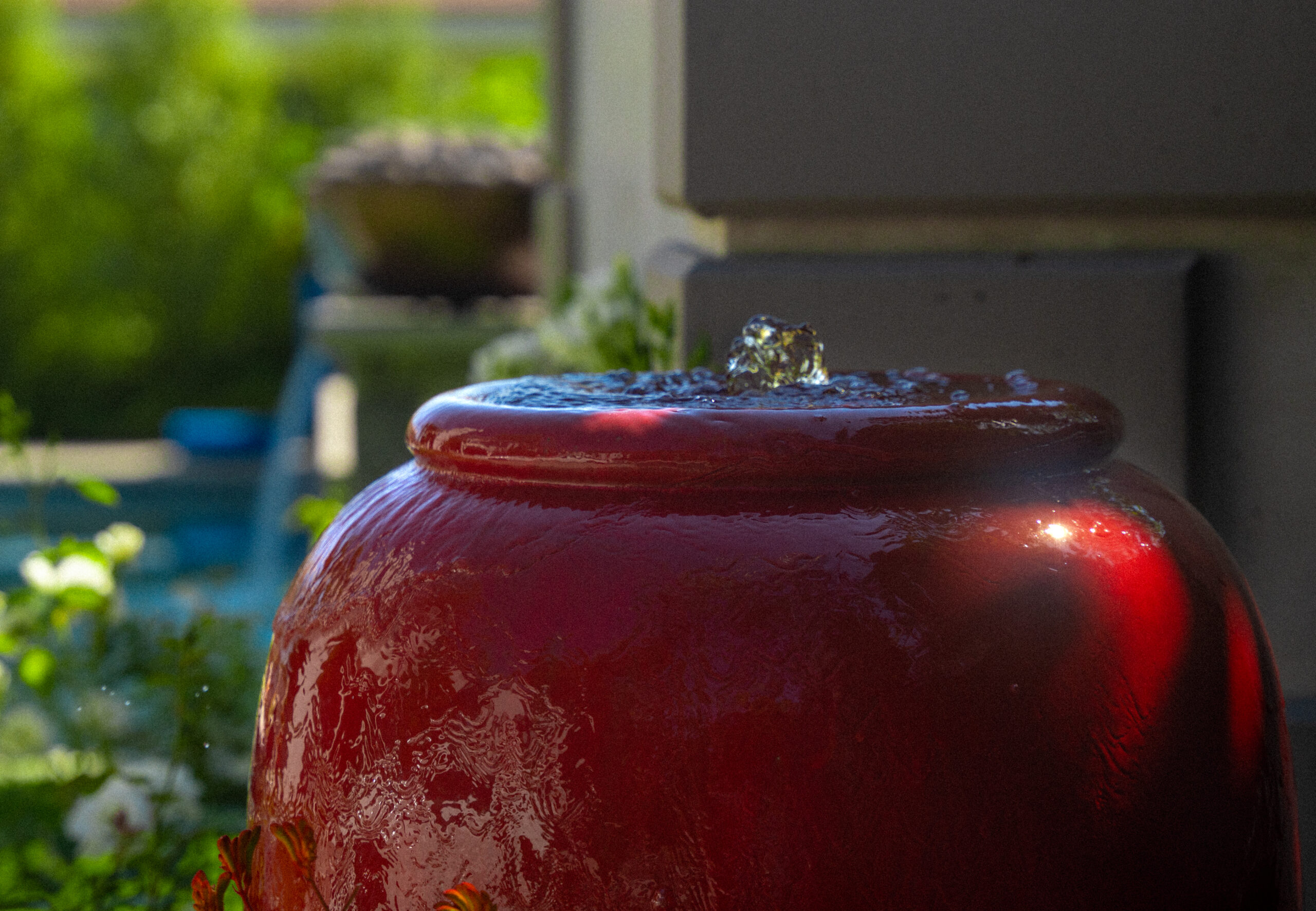 Ceramic bubbling fountain surrounded by garden planting