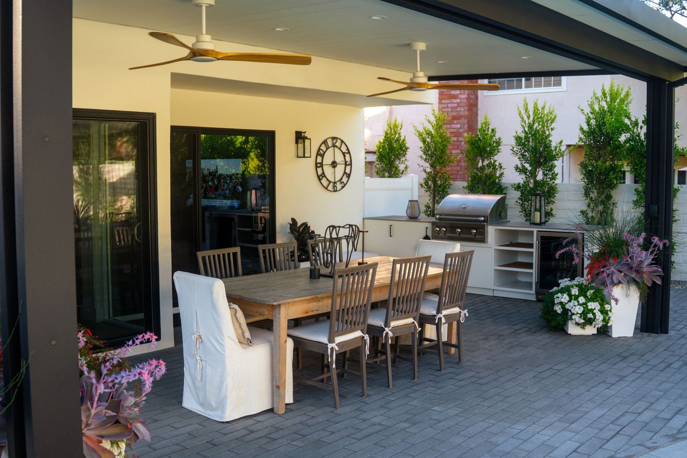 Covered patio dining area with outdoor kitchen in a backyard