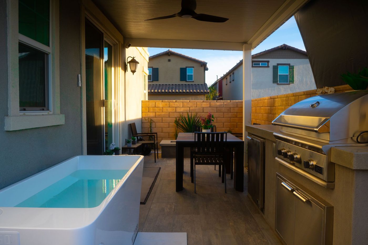 A compact plunge pool in a narrow side yard beside covered dining