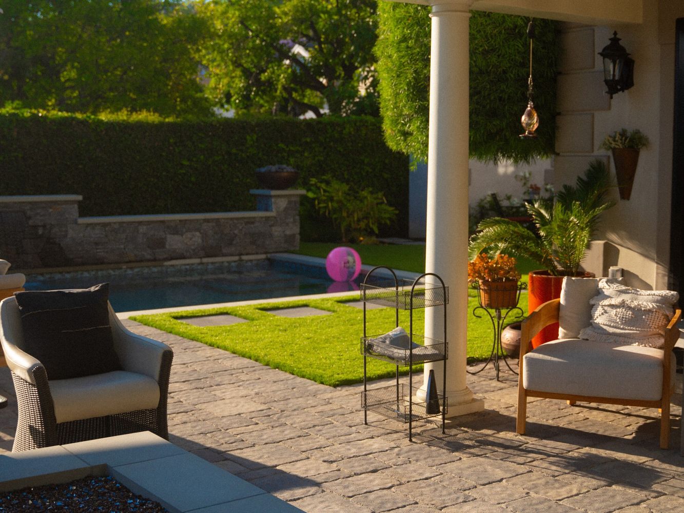 Covered patio with seating overlooking a backyard pool