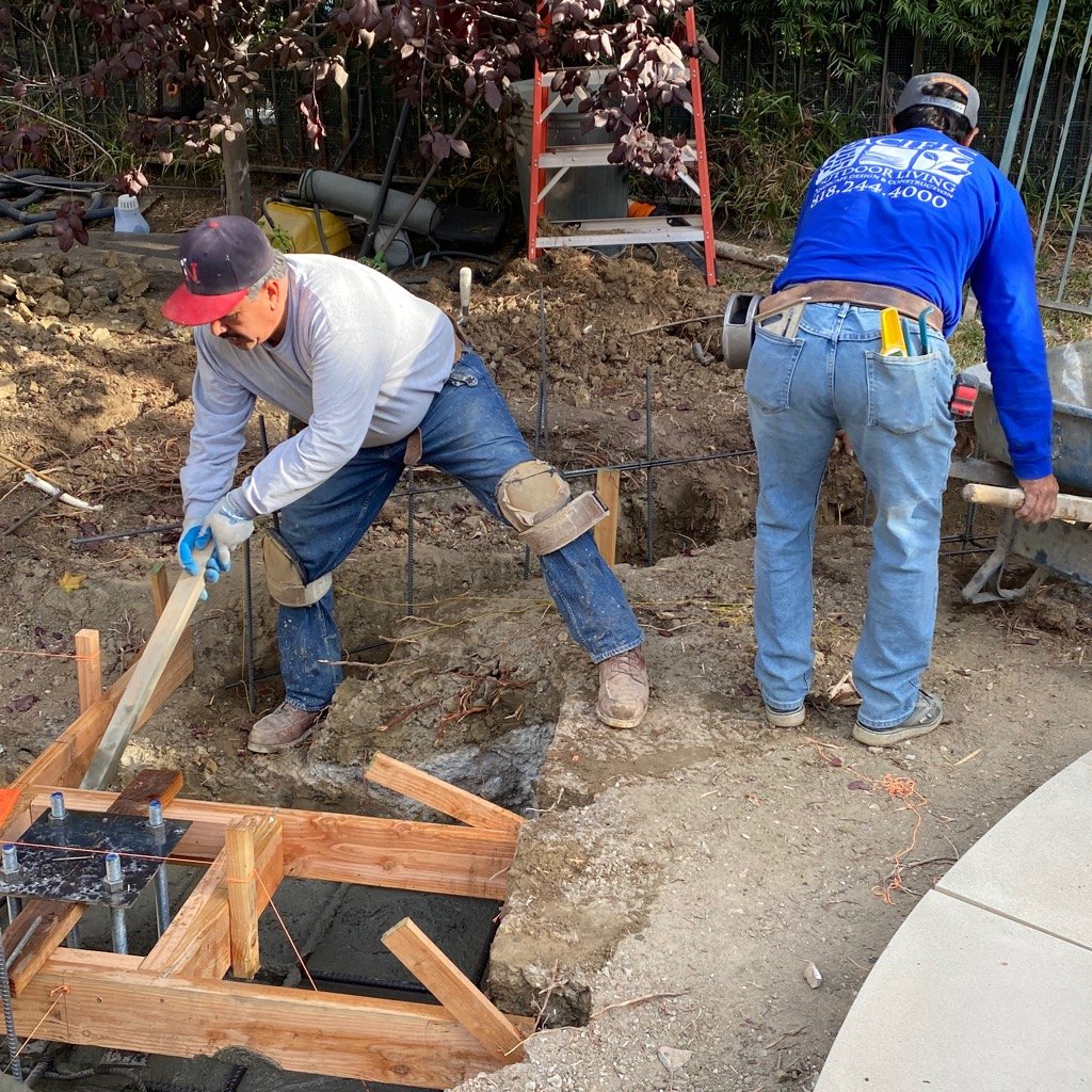 Pacific Outdoor Living crew members preparing rebar and concrete forms during site construction