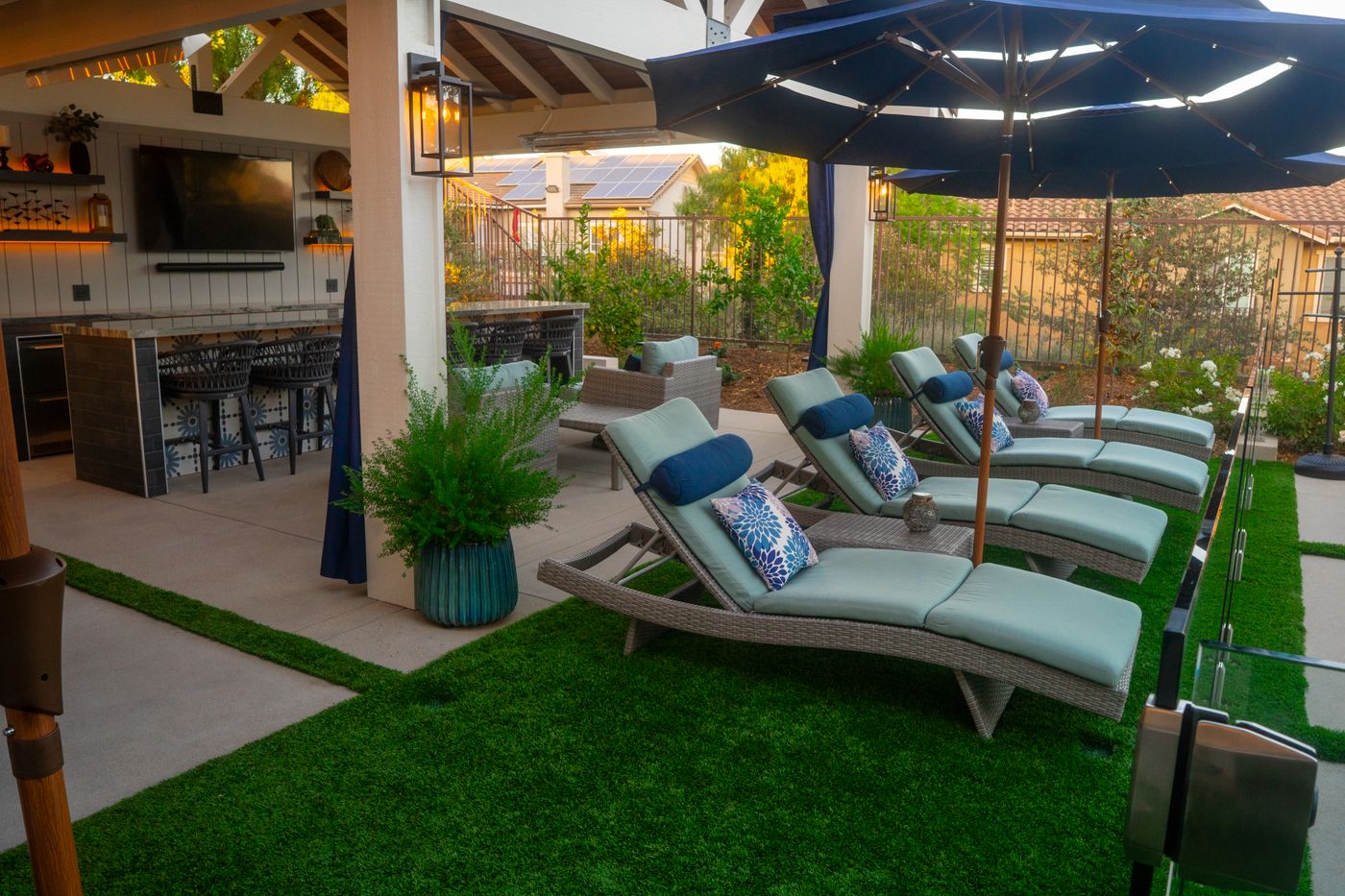 Pergola shade structure over an outdoor seating area in a sunny backyard
