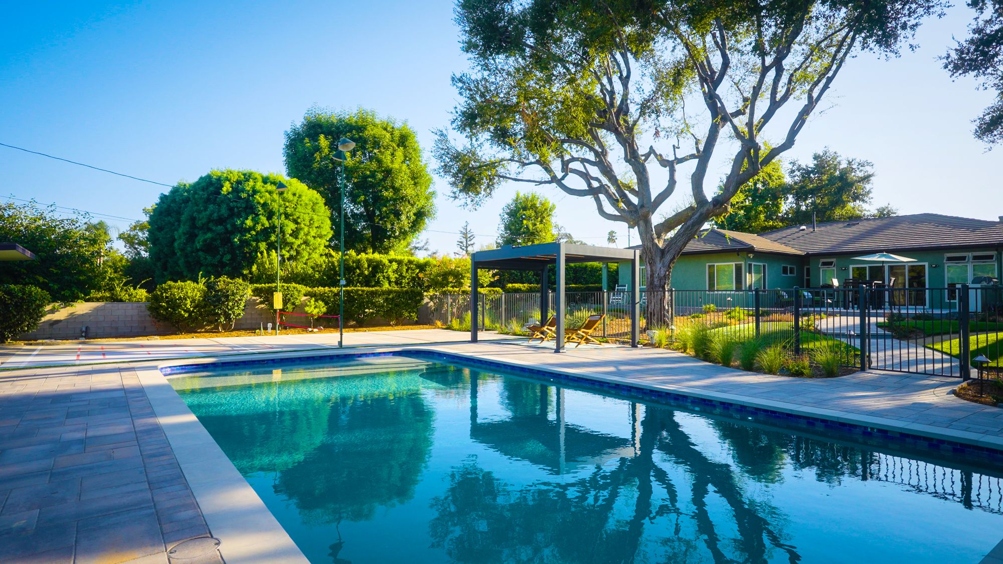 Modern backyard pool with pergola and landscape design
