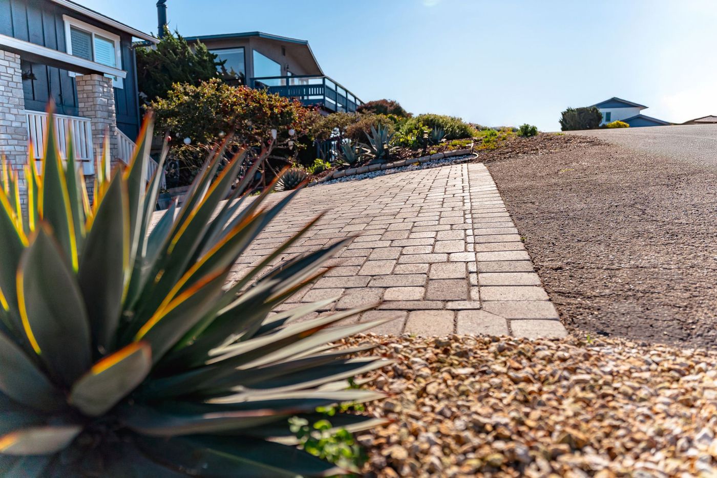 Interlocking paver driveway installed at a coastal Morro Bay home with landscaped planting beds.