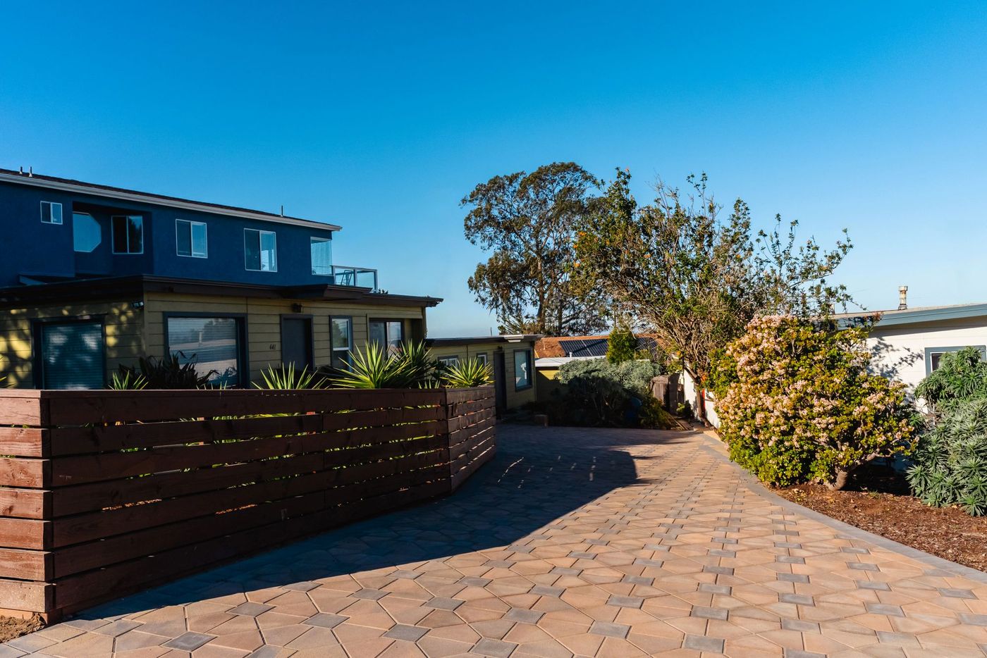 Curved paver driveway framing a property with harbor view backdrop