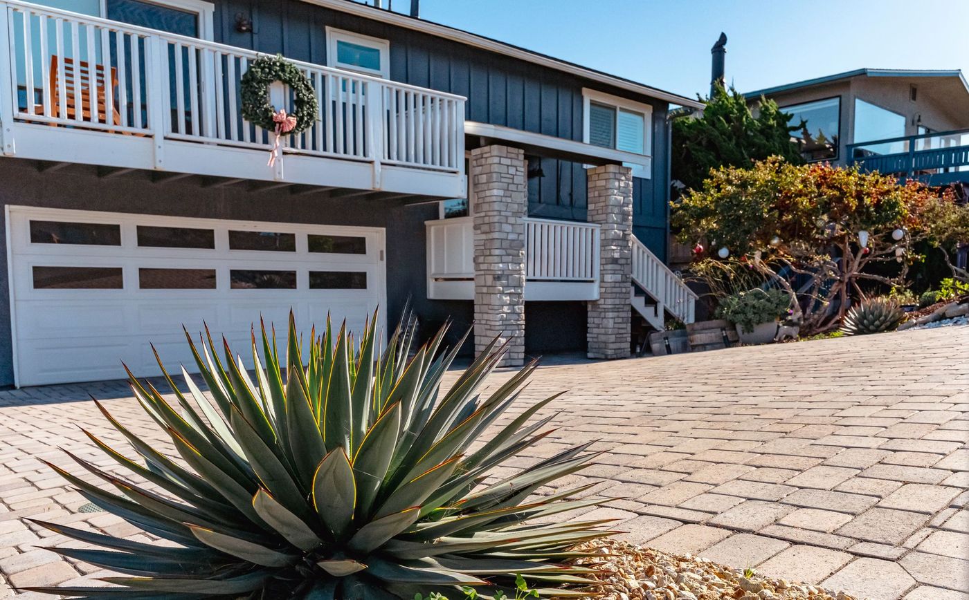Sloped paver driveway installation in Morro Bay featuring drought-tolerant landscaping and agave plants.