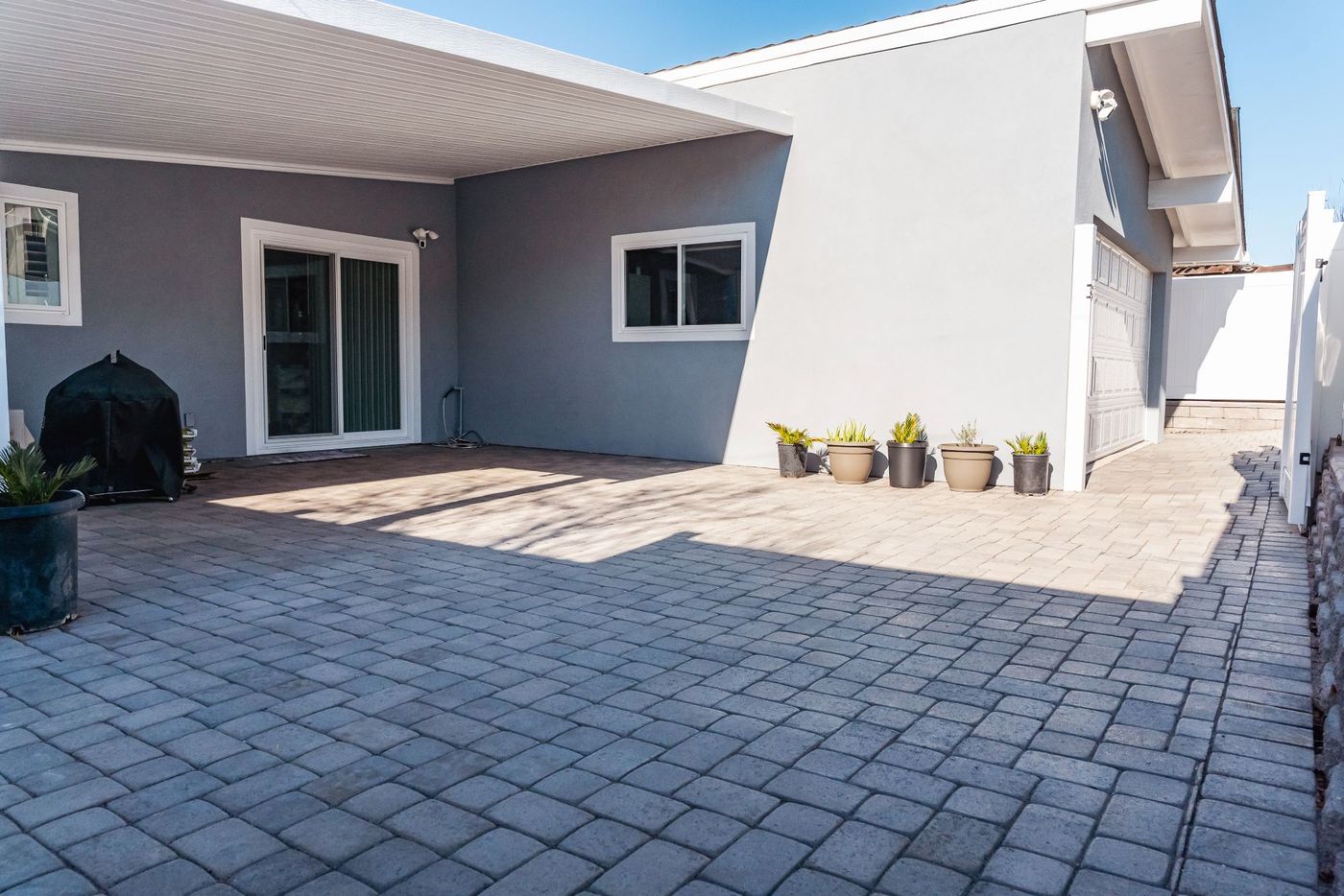 Concrete paver patio and driveway extension installed in a Morro Bay coastal home backyard.