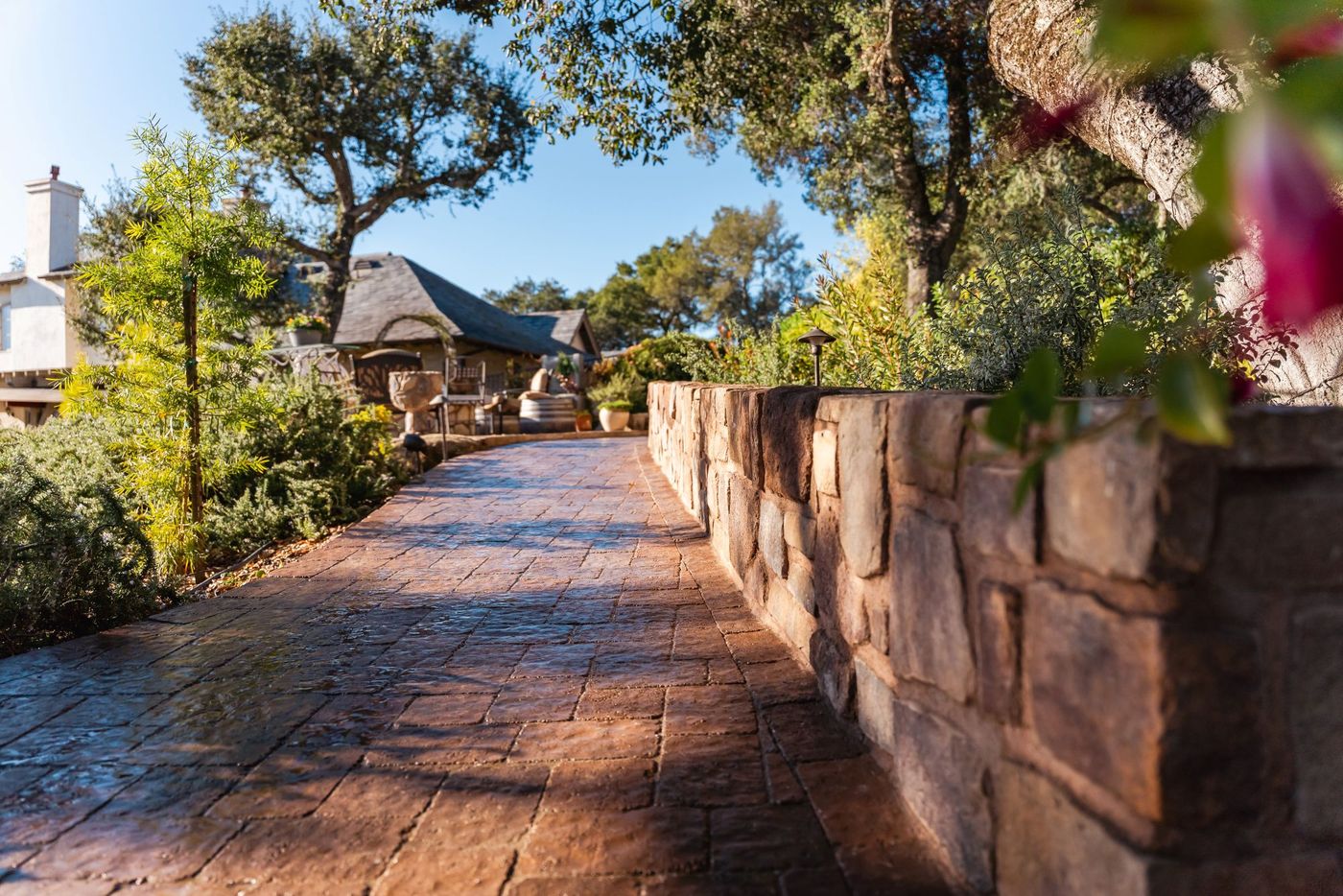 Curved paver walkway installation in Paso Robles accented with natural landscape boulders and garden lighting.
