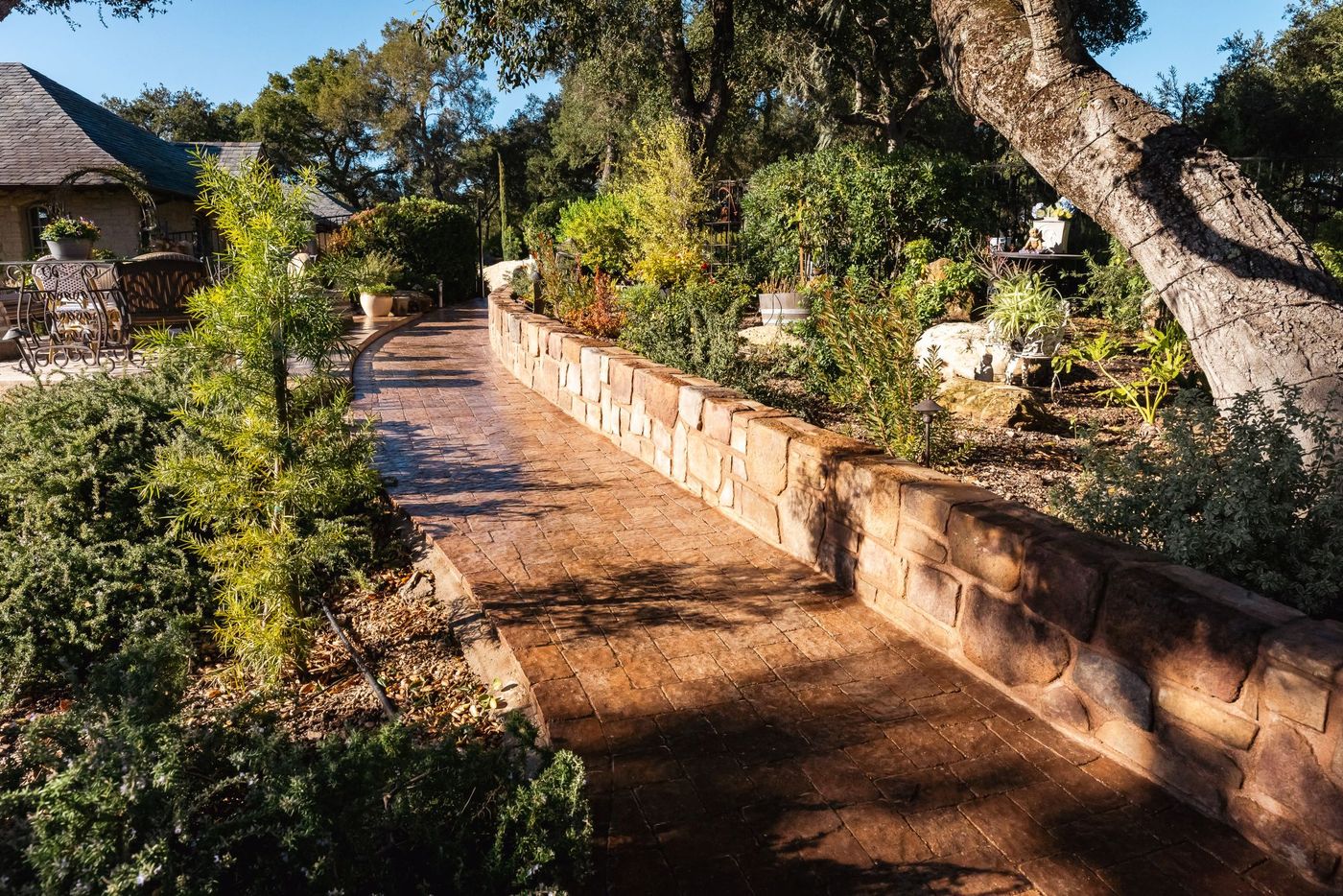 Custom paver walkway in Paso Robles with decorative stone urn and integrated landscape lighting.