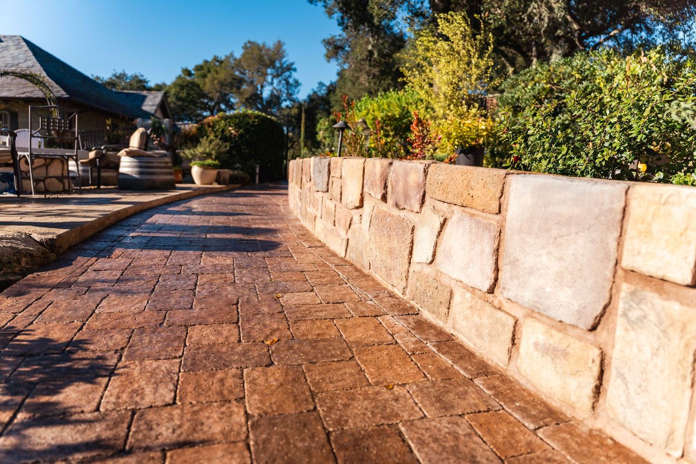 Curved stamped concrete paver walkway in Paso Robles leading toward an elevated patio and outdoor seating space.