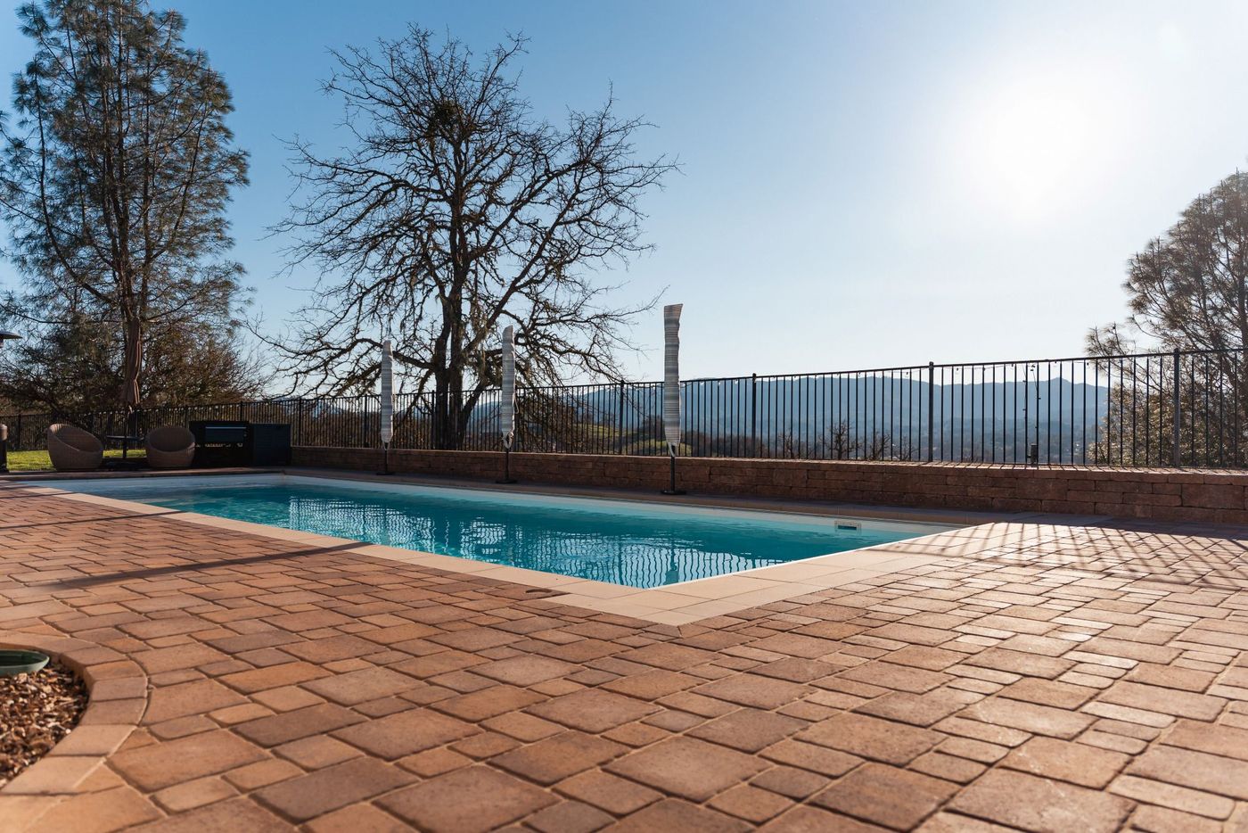 Transformed backyard pool in San Luis Obispo featuring a custom paver deck and expansive hillside views.