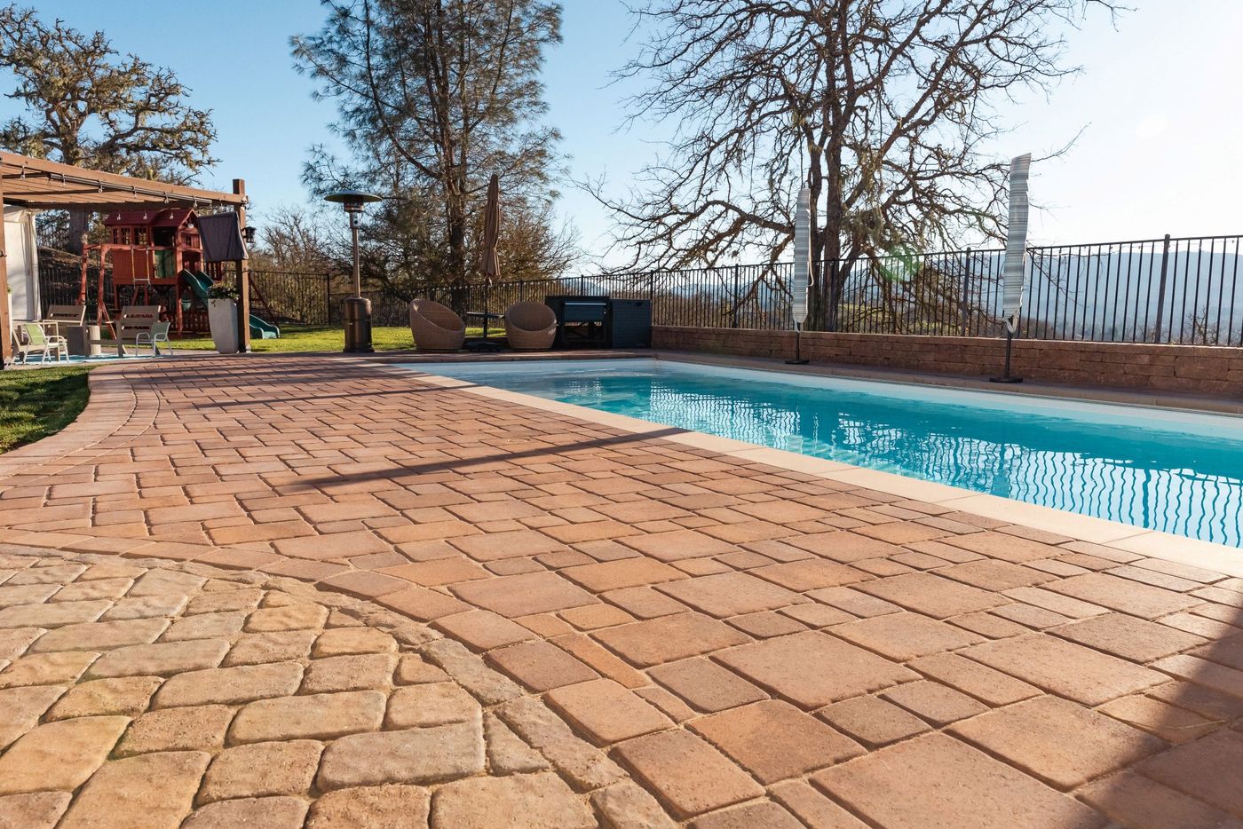 San Luis Obispo pool renovation showcasing expanded paver pool deck, upgraded hardscape, and outdoor family recreation space.