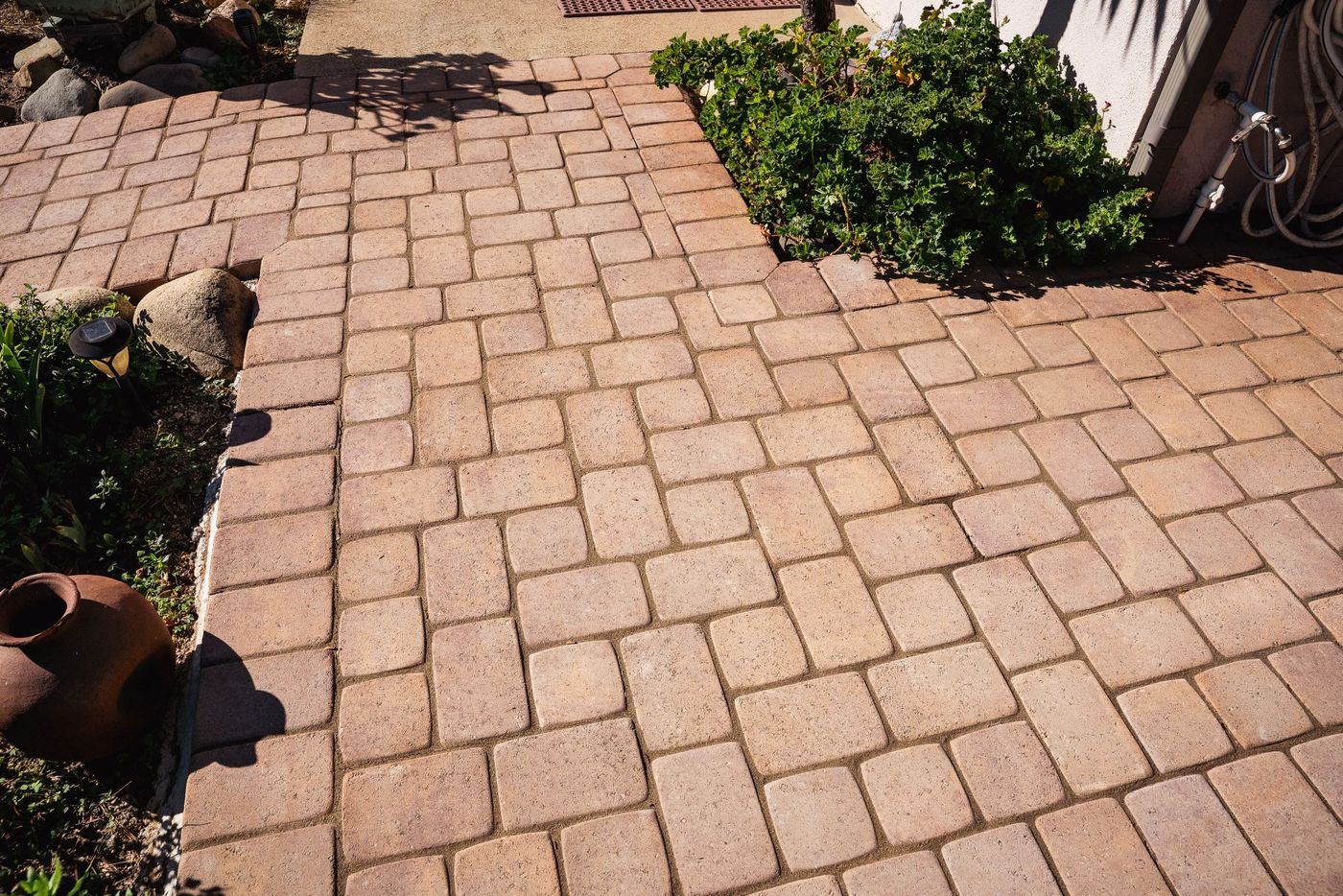 Front yard hardscape installation in San Luis Obispo featuring interlocking pavers and natural stone edging.