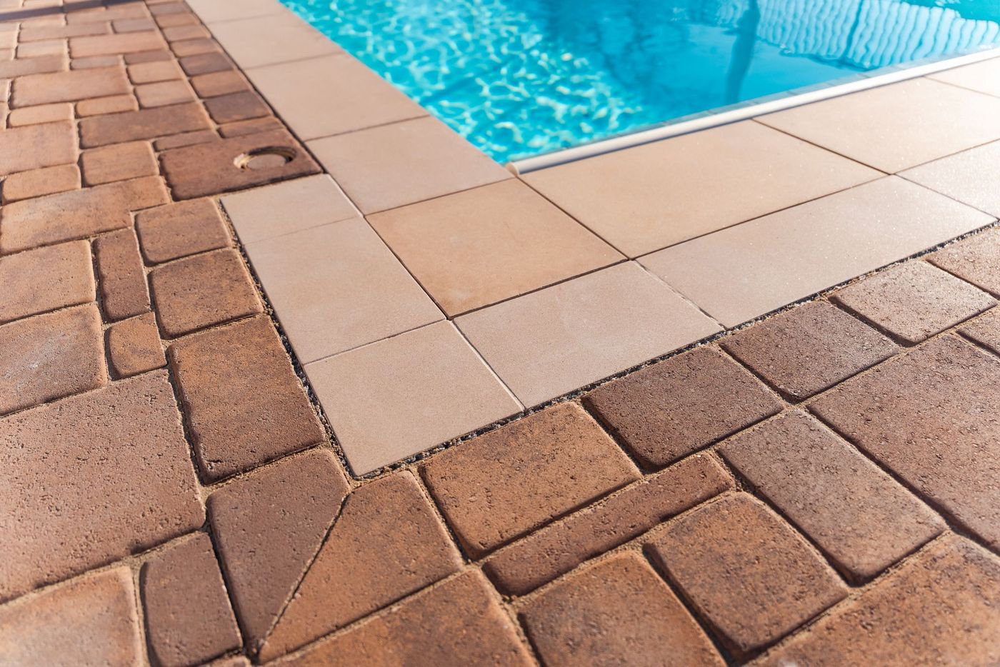 Close-up of pool coping and contrasting paver border installed during a San Luis Obispo pool renovation project.