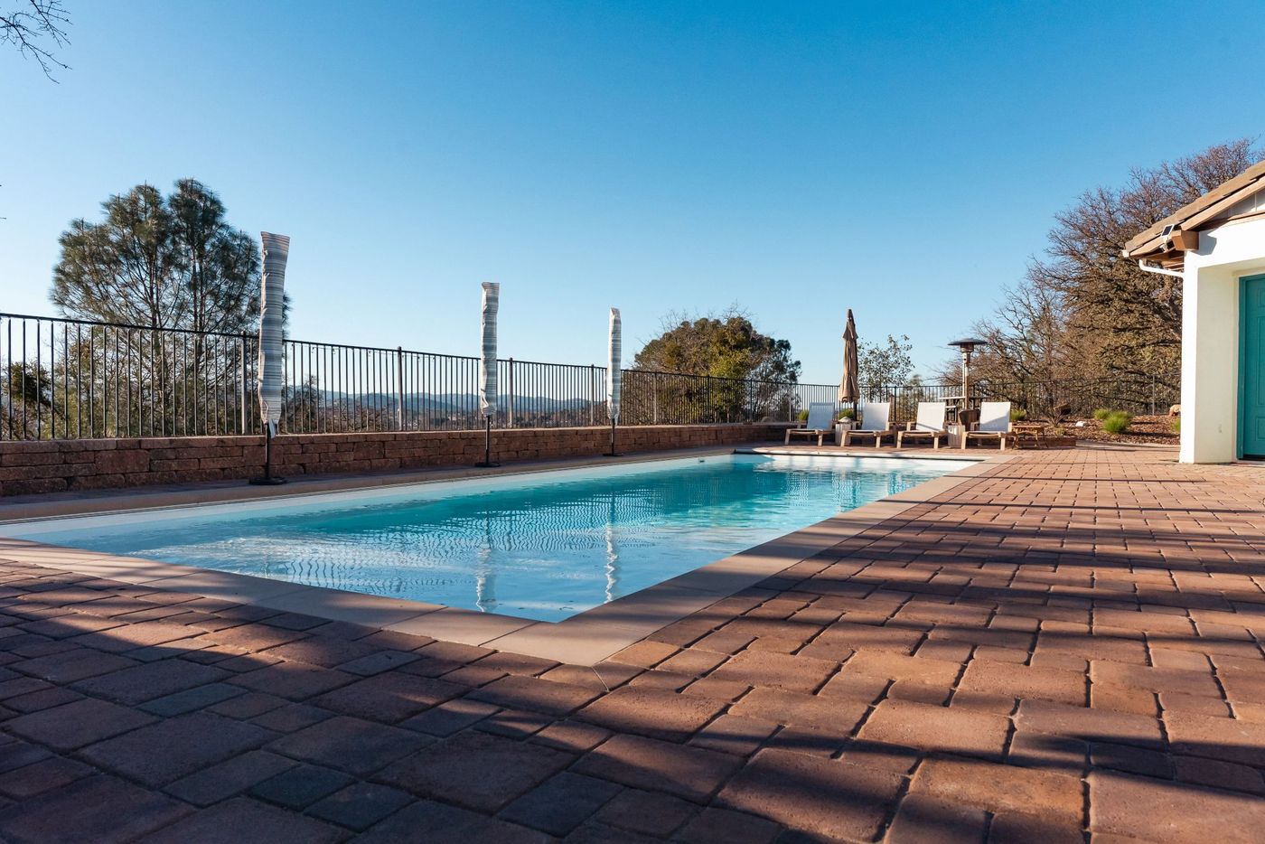 Custom pool transformation in San Luis Obispo featuring a rectangular swimming pool with upgraded paver deck and scenic hillside views.
