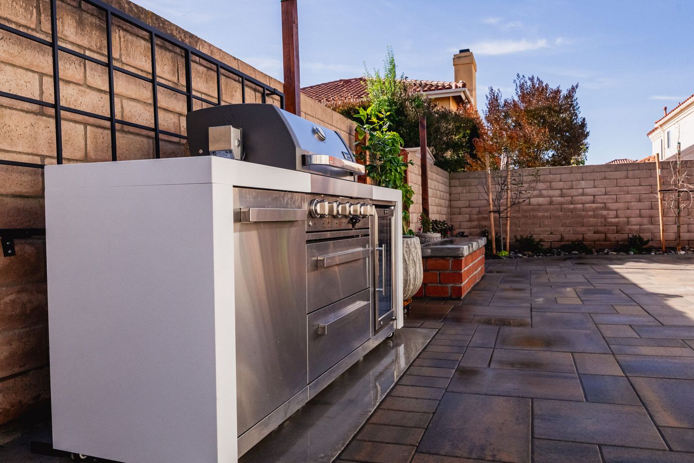Custom outdoor kitchen with stainless steel grill installed on a Santa Maria paver patio.