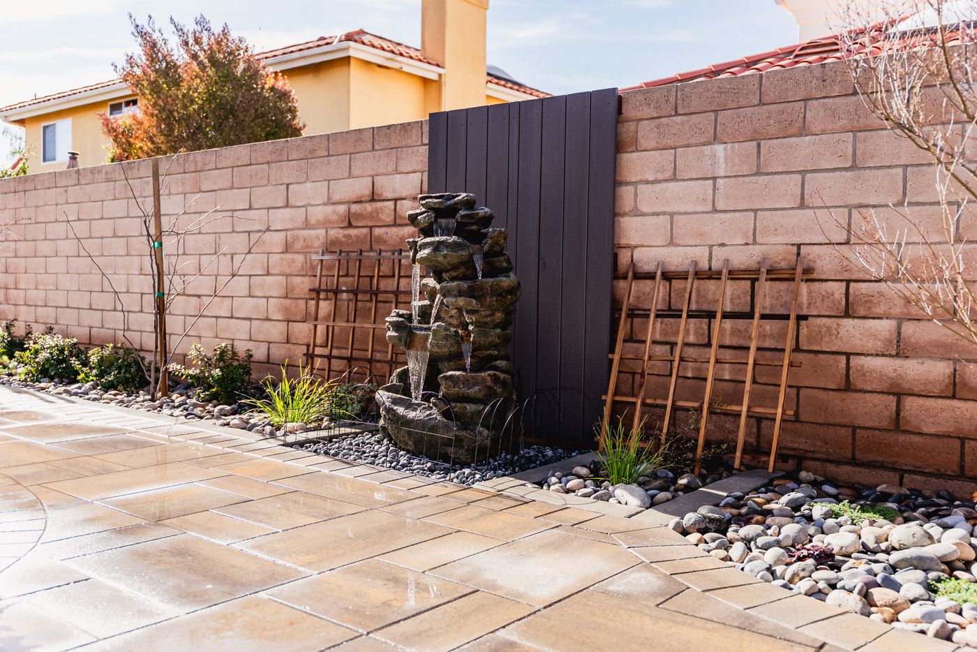 Natural-style rock waterfall water feature integrated into a Santa Maria backyard side yard landscape.