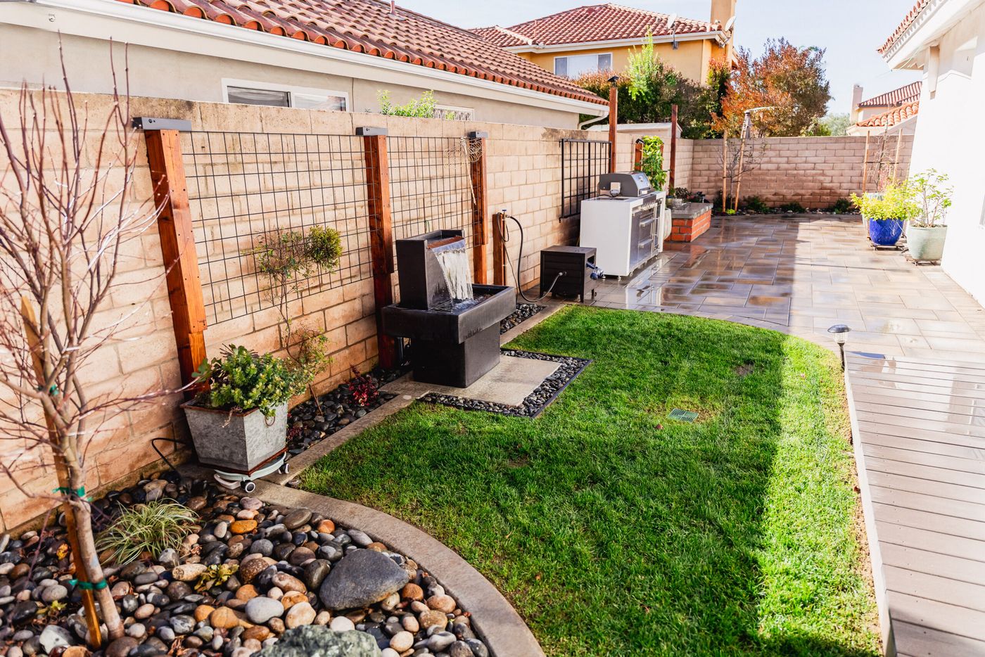Complete side yard landscape renovation in Santa Maria featuring paver patio, lawn, water features, and outdoor kitchen.