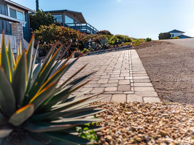 Interlocking paver driveway installed at a coastal Morro Bay home with landscaped planting beds.