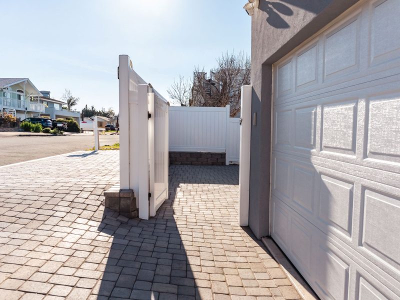 Custom paver driveway installation in Morro Bay leading to a residential garage with clean concrete edging.