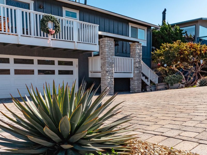 Sloped paver driveway installation in Morro Bay featuring drought-tolerant landscaping and agave plants.