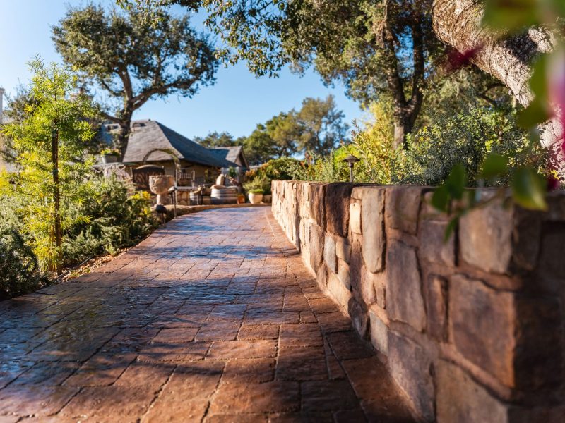 Curved paver walkway installation in Paso Robles accented with natural landscape boulders and garden lighting.